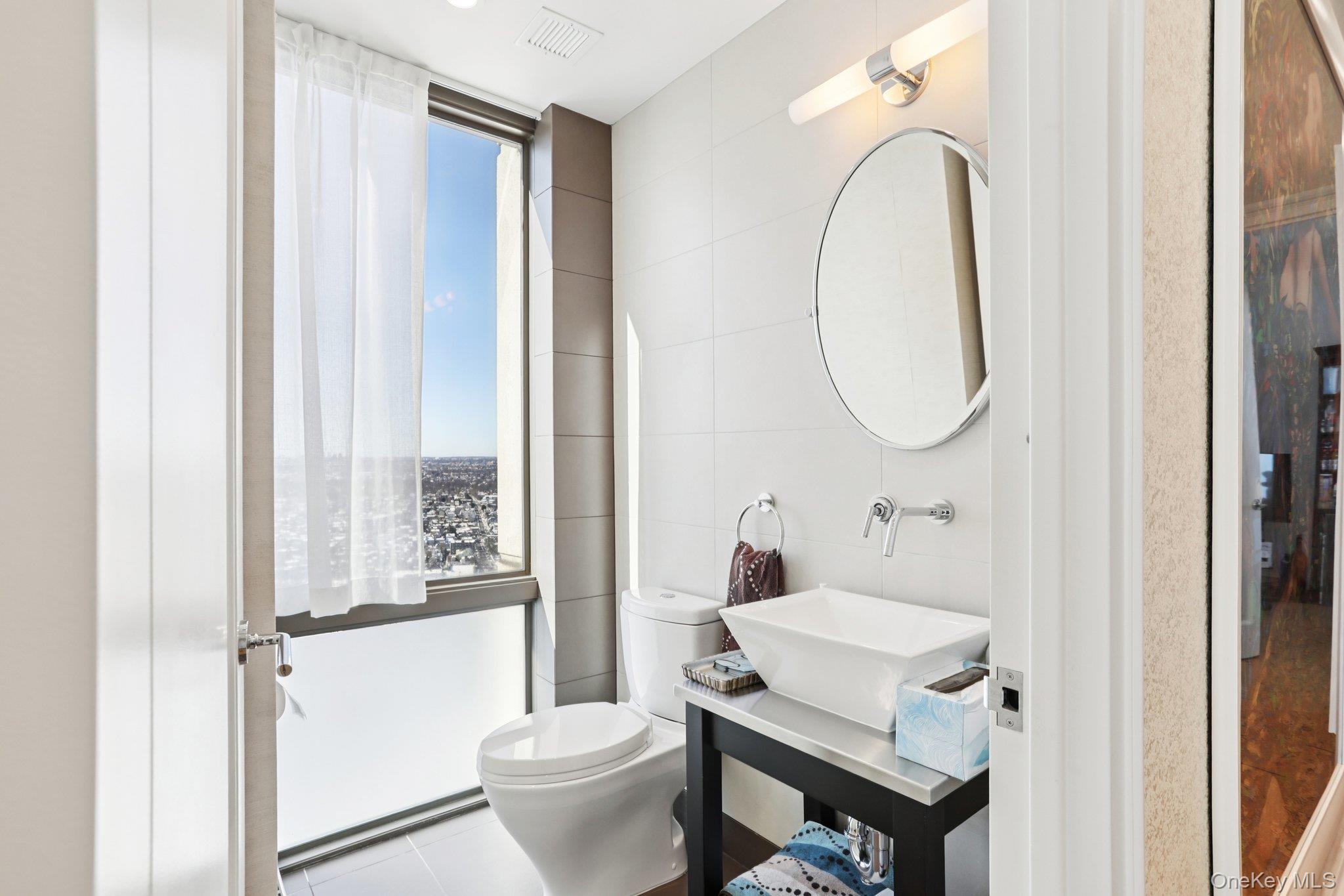 175 Huguenot Street, Unit PH302 New Rochelle, NY 10801 - Photo 12 of 25 a bathroom with a sink toilet and a mirror