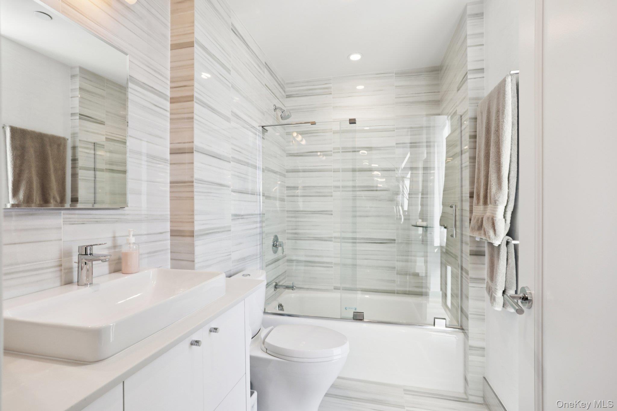 175 Huguenot Street, Unit PH302 New Rochelle, NY 10801 - Photo 13 of 25 a bathroom with a sink a toilet and shower