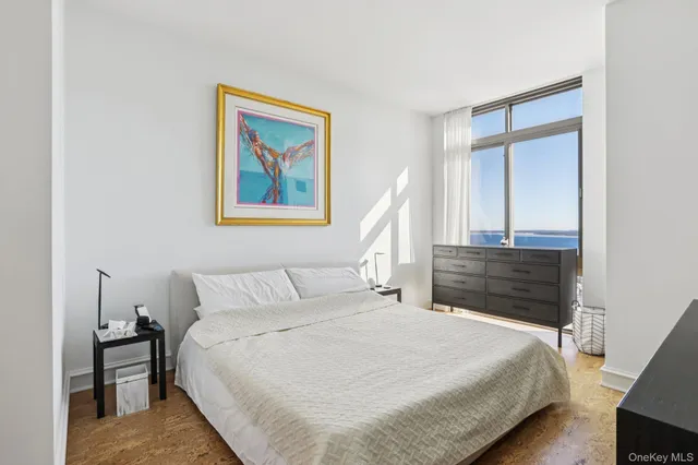 a bedroom with a bed and a painting on the wall