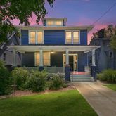 a front view of a house with a yard and potted plants