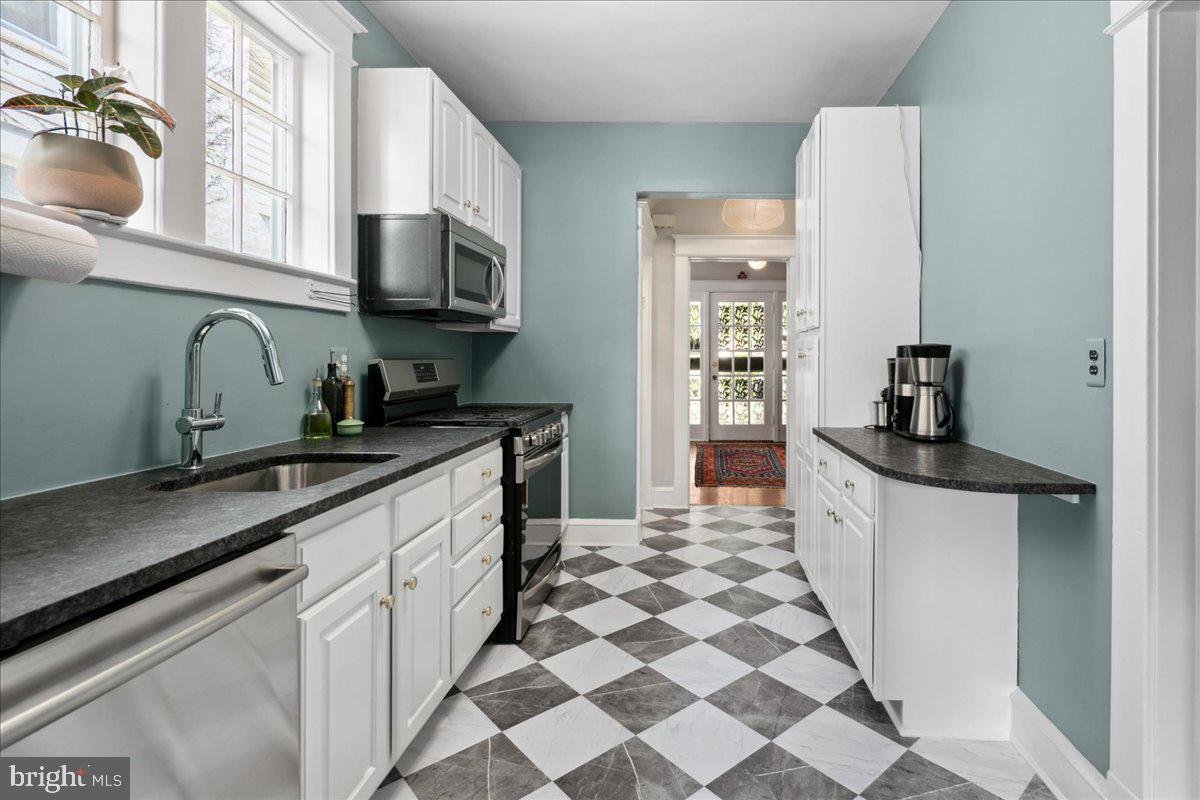 6721 Piney Branch Road Northwest Washington, DC 20012 - Photo 31 of 78 a kitchen with stainless steel appliances a sink a stove top oven a chimney a sink and cabinets
