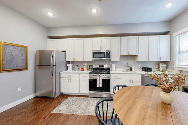 a kitchen with a refrigerator a stove top oven a sink and cabinets