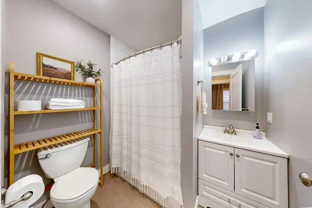 a bathroom with a granite countertop toilet sink and mirror