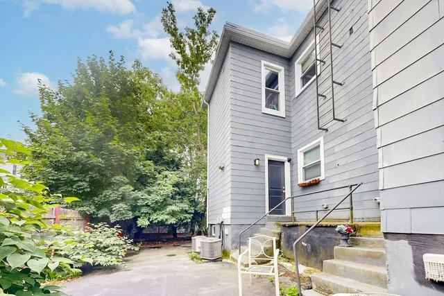 a backyard of a house with table and chairs