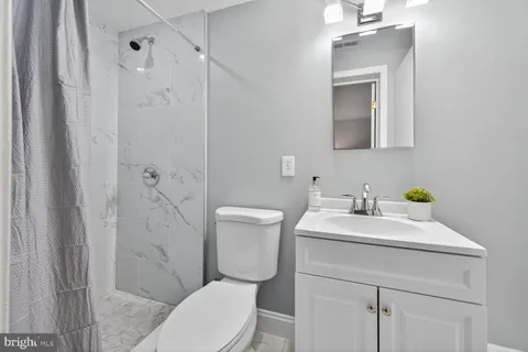 a bathroom with a sink toilet vanity and shower