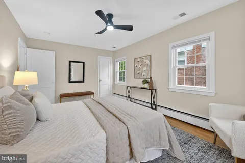 a bedroom with a bed wooden floor and window