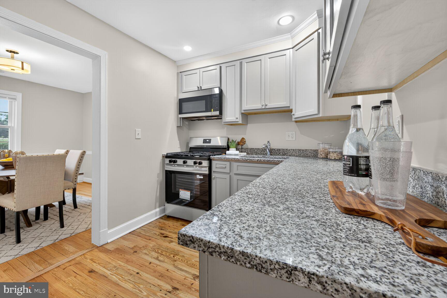 2813 Laurel Avenue Cheverly, MD 20785 - Photo 7 of 30 a kitchen with stainless steel appliances granite countertop a sink stove and refrigerator