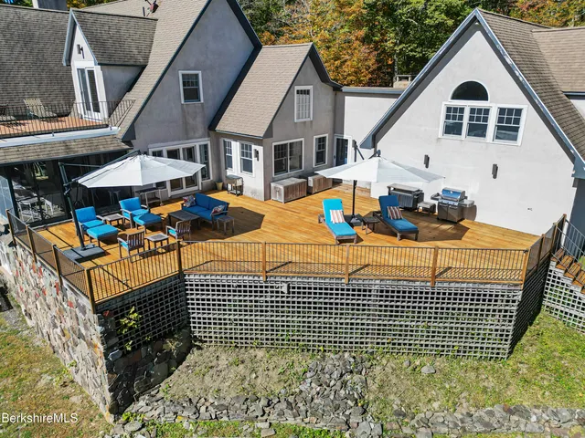 a dining room with wooden floor a chandelier a wooden table and chairs