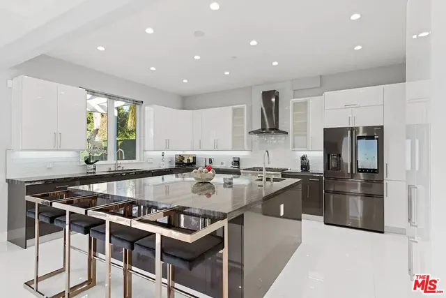 a kitchen with stainless steel appliances granite countertop a stove top oven a sink dishwasher a dining table and chairs