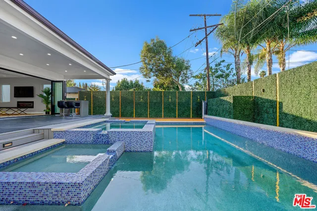 a view of swimming pool with a patio and a garden