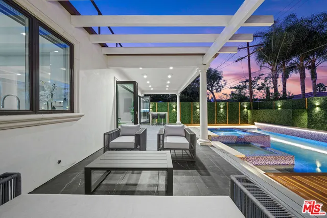 a living room with patio furniture and a swimming pool