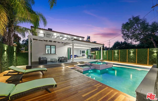 a view of a house with swimming pool and sitting area