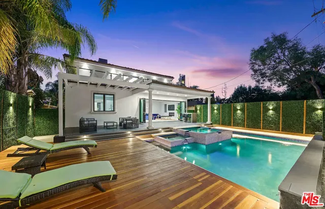 a view of a house with swimming pool and sitting area