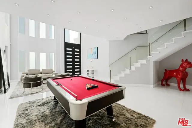 a room with pool table and windows
