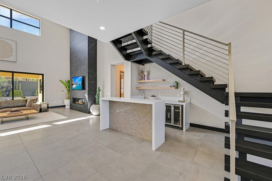 53 Garibaldi Way Henderson, NV 89011 - Photo 14 of 80 Indoor wet bar with open shelves, stairway, plenty of natural light, light tile patterned floors, and recessed lighting