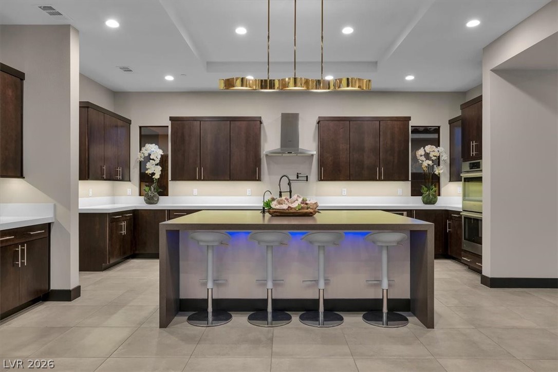 53 Garibaldi Way Henderson, NV 89011 - Photo 18 of 80 Kitchen with a kitchen breakfast bar, a kitchen island with sink, light stone counters, pendant lighting, and recessed lighting