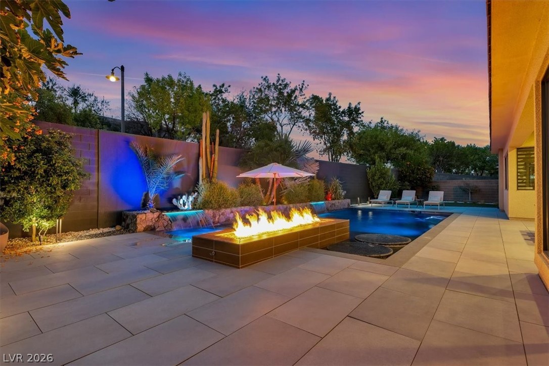 53 Garibaldi Way Henderson, NV 89011 - Photo 2 of 80 Pool at dusk with a patio area, a fenced backyard, and an outdoor fire pit