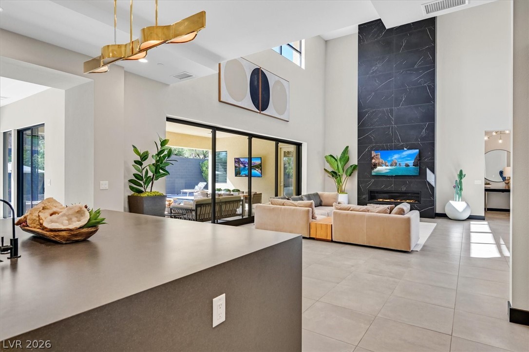 53 Garibaldi Way Henderson, NV 89011 - Photo 23 of 80 Living area with a high end fireplace, light tile patterned flooring, and a towering ceiling