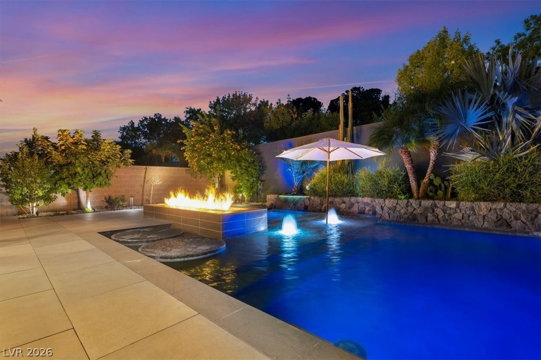 53 Garibaldi Way Henderson, NV 89011 - Photo 3 of 80 Pool at dusk featuring a patio area, a fenced backyard, and a fire pit