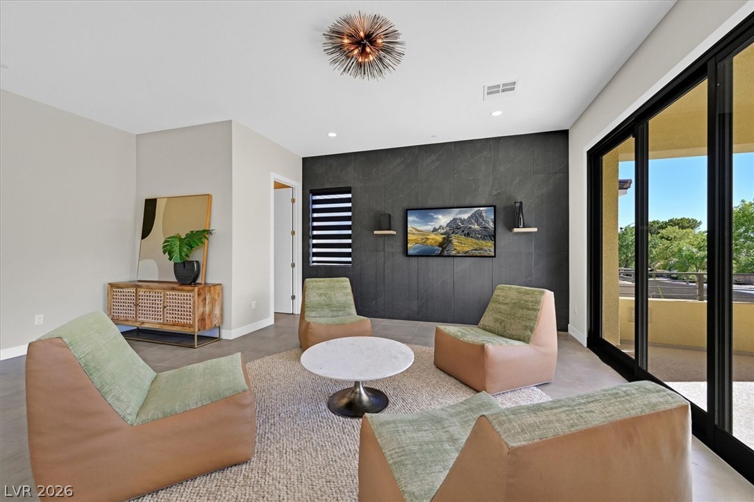 53 Garibaldi Way Henderson, NV 89011 - Photo 43 of 80 Living area featuring an accent wall, recessed lighting, and finished concrete floors