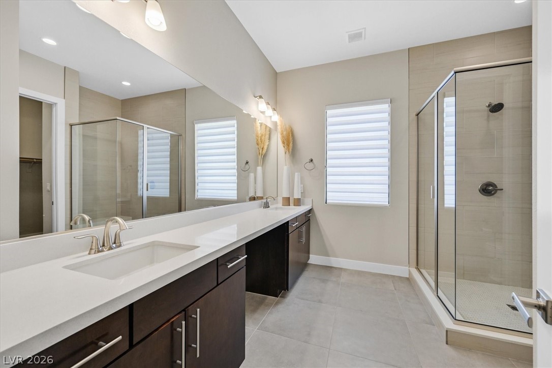 53 Garibaldi Way Henderson, NV 89011 - Photo 47 of 80 Bathroom with a stall shower, double vanity, a spacious closet, light tile patterned flooring, and recessed lighting