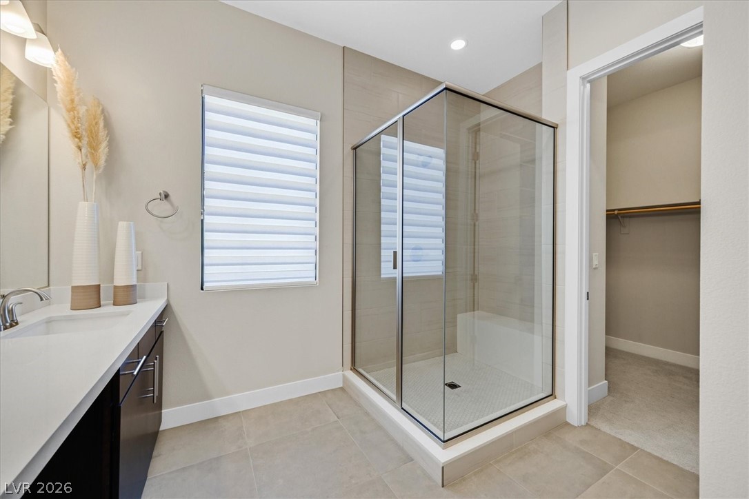 53 Garibaldi Way Henderson, NV 89011 - Photo 48 of 80 Bathroom with vanity, a shower stall, light tile patterned floors, and a spacious closet