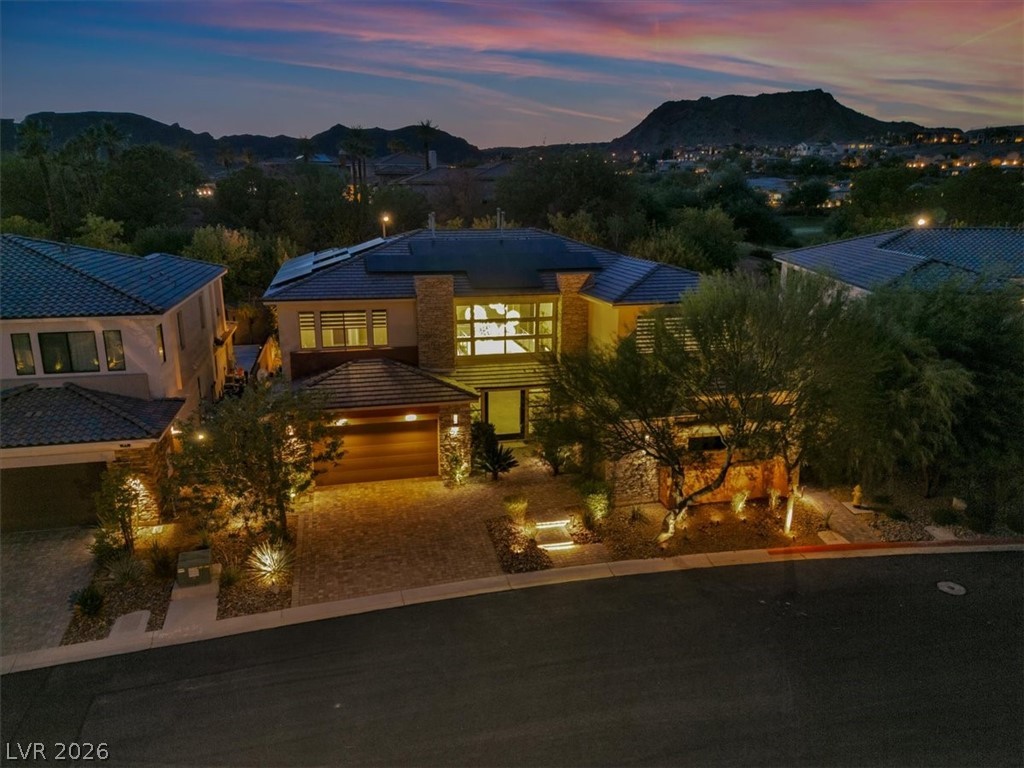 53 Garibaldi Way Henderson, NV 89011 - Photo 72 of 80 View of front of house with roof mounted solar panels, a mountain view, decorative driveway, a garage, and stucco siding