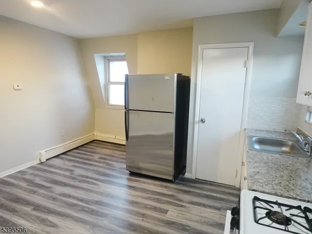 a view of kitchen with hallway and wooden floor