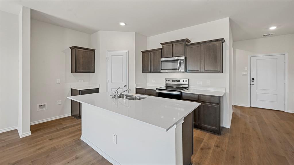 3343 Spaulding Drive Paris, TX 75460 - Photo 23 of 35 a kitchen with kitchen island a sink appliances and cabinets