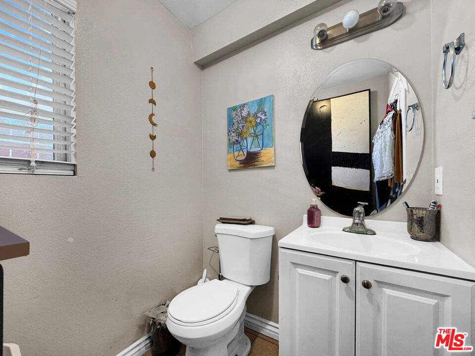 13258 Filmore Street Pacoima, CA 91331 - Photo 15 of 30 a bathroom with a toilet sink and mirror
