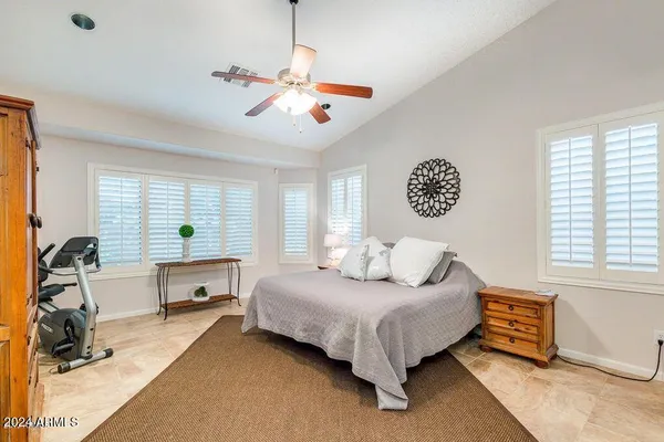 a spacious bedroom with a bed and a chandelier