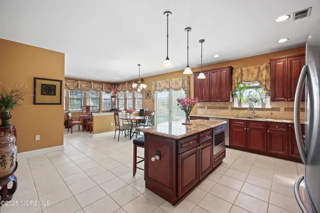 a kitchen with stainless steel appliances granite countertop a refrigerator a sink a stove and a oven