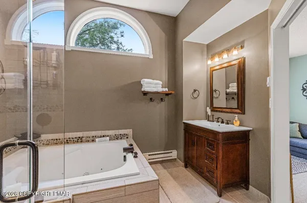 a bathroom with a tub sink and mirror