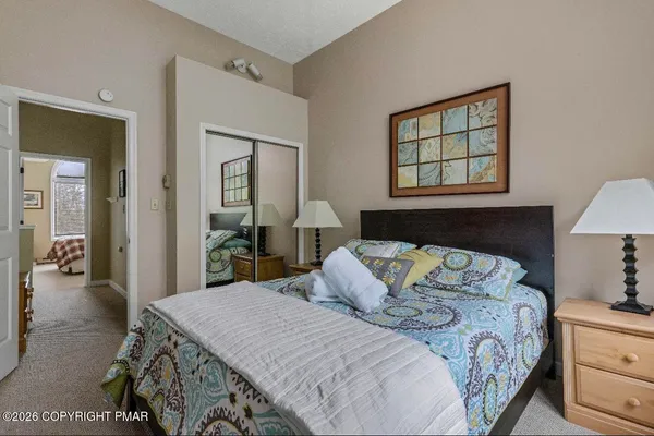 a bedroom with a bed and a lamp on dresser