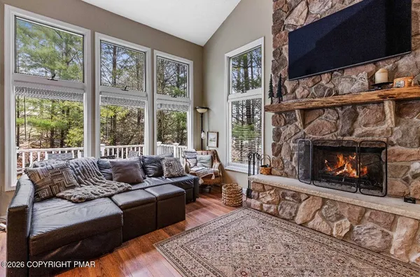 a living room with furniture a flat screen tv and a fireplace