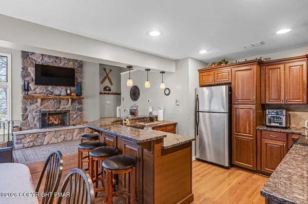 a kitchen with stainless steel appliances granite countertop a refrigerator and a stove top oven