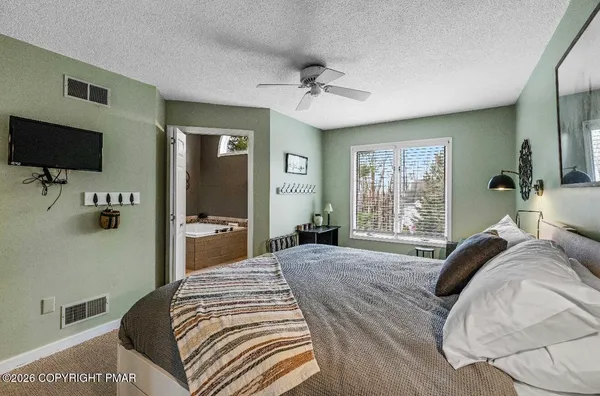 a bedroom with a bed and a flat screen tv