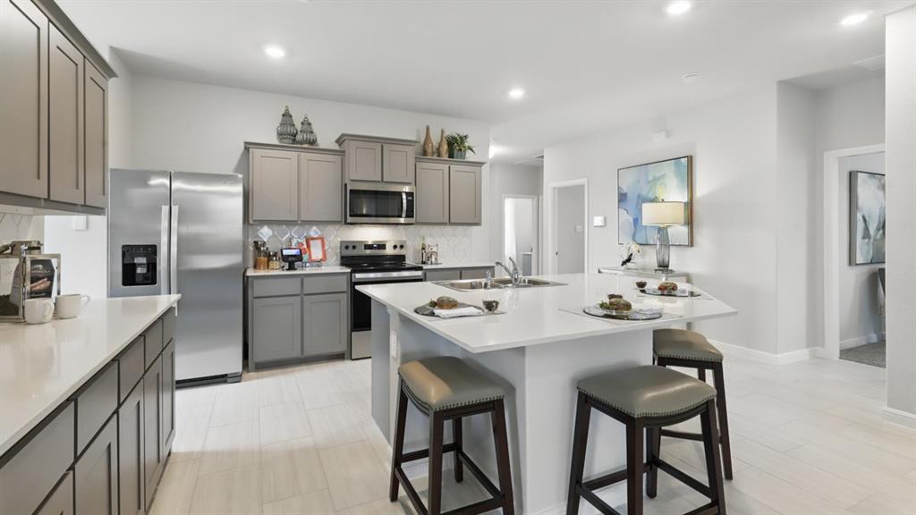 9708 Austin Holw Road Fort Worth, TX 76036 - Photo 6 of 35 a kitchen with kitchen island a sink stove and refrigerator