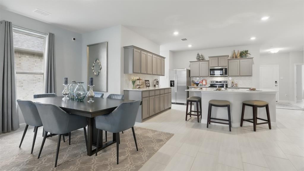 9708 Austin Holw Road Fort Worth, TX 76036 - Photo 8 of 35 a kitchen with kitchen island a dining table and chairs