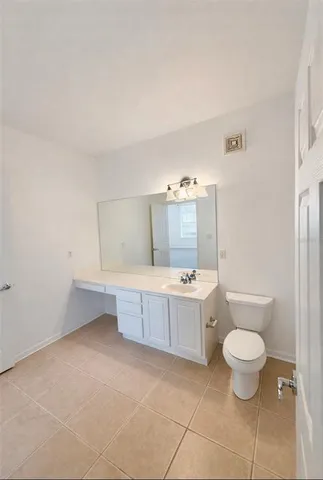 a bathroom with a granite countertop sink a toilet and a mirror