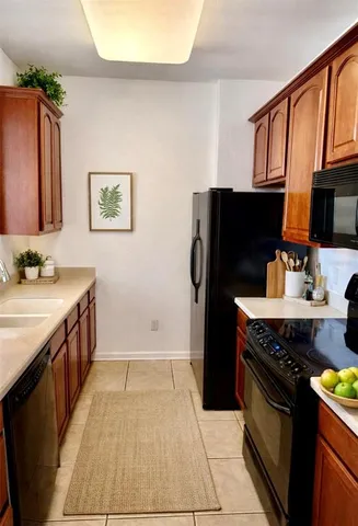 a kitchen with stainless steel appliances granite countertop a stove top oven a sink dishwasher and a refrigerator