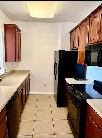 a kitchen with stainless steel appliances granite countertop a refrigerator and a stove