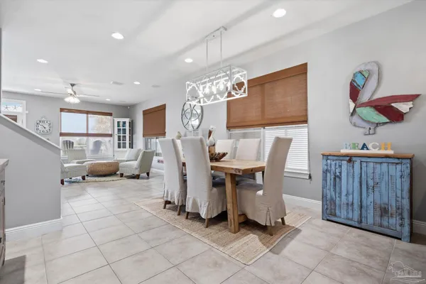 a kitchen with stainless steel appliances granite countertop a stove top oven a sink dishwasher a dining table and chairs