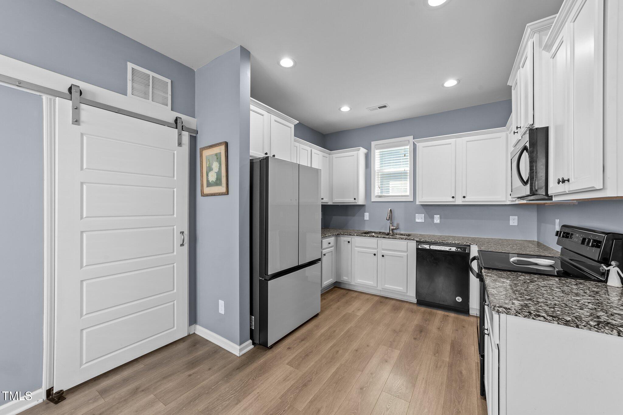 166 Yellow Jacket Ridge Clayton, NC 27520 - Photo 11 of 39 a kitchen with stainless steel appliances granite countertop a refrigerator and a stove top oven