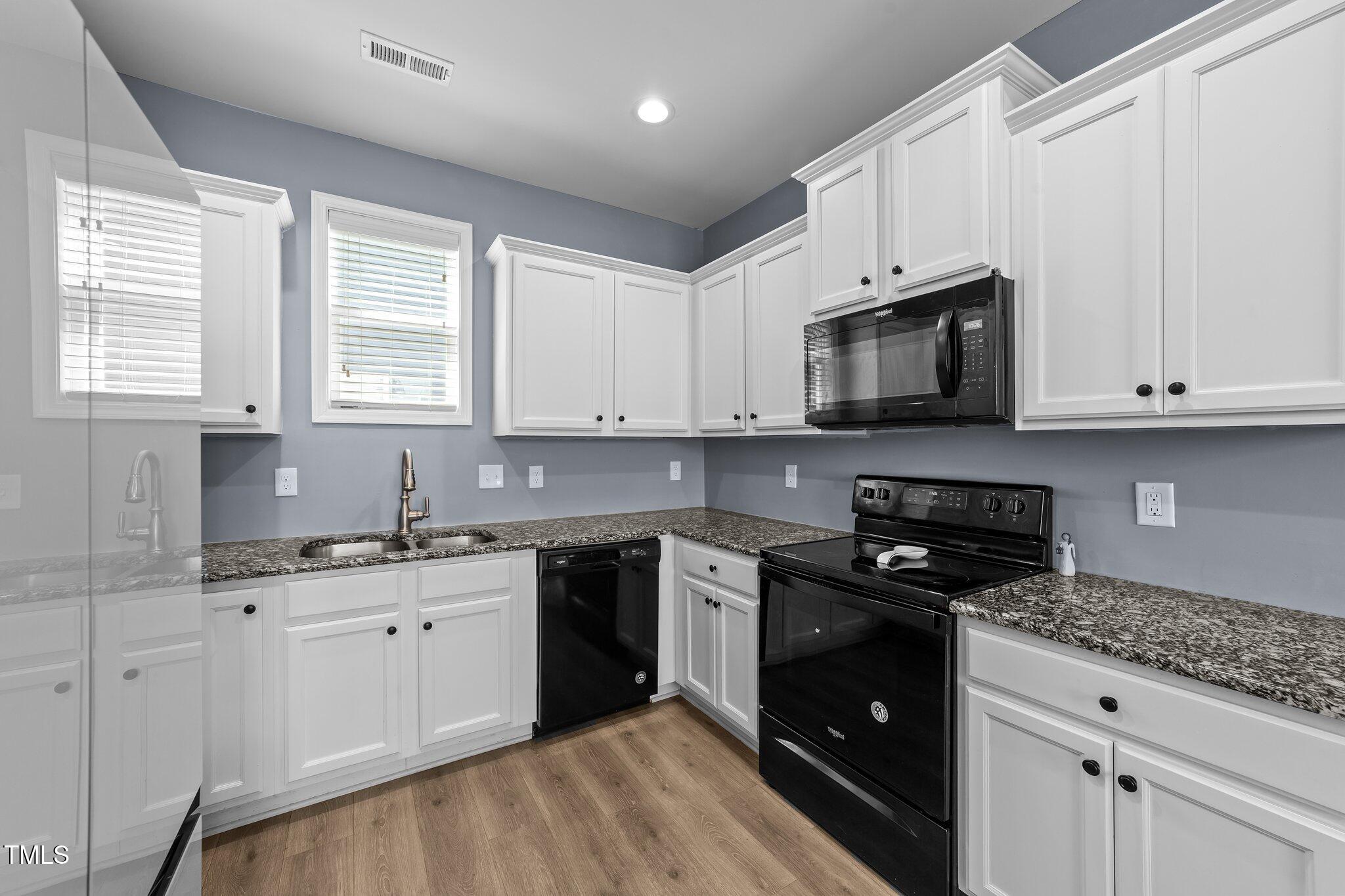 166 Yellow Jacket Ridge Clayton, NC 27520 - Photo 12 of 39 a kitchen with stainless steel appliances granite countertop white cabinets granite counter tops and a window