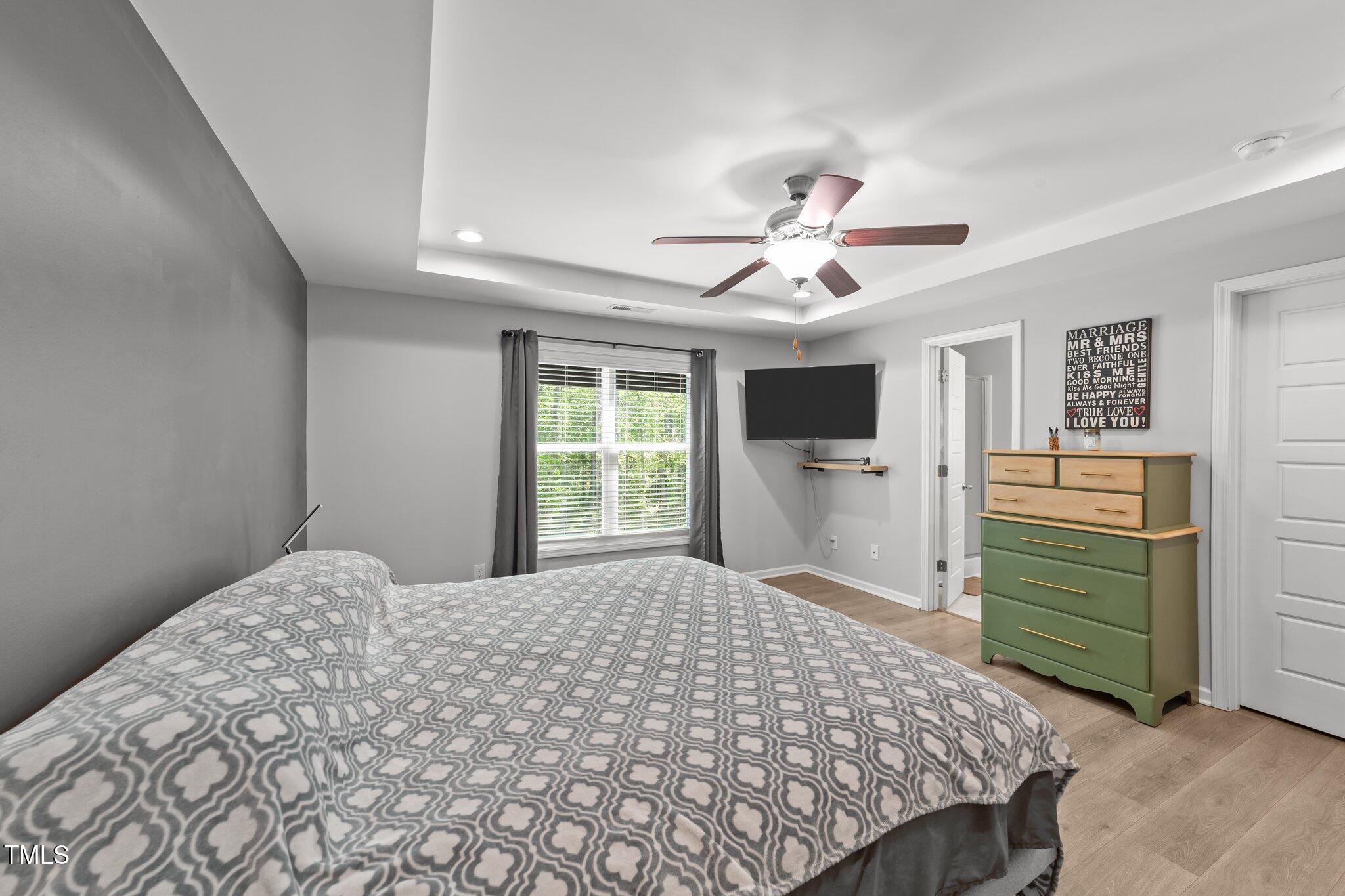 166 Yellow Jacket Ridge Clayton, NC 27520 - Photo 18 of 39 a bedroom with a bed and a chandelier