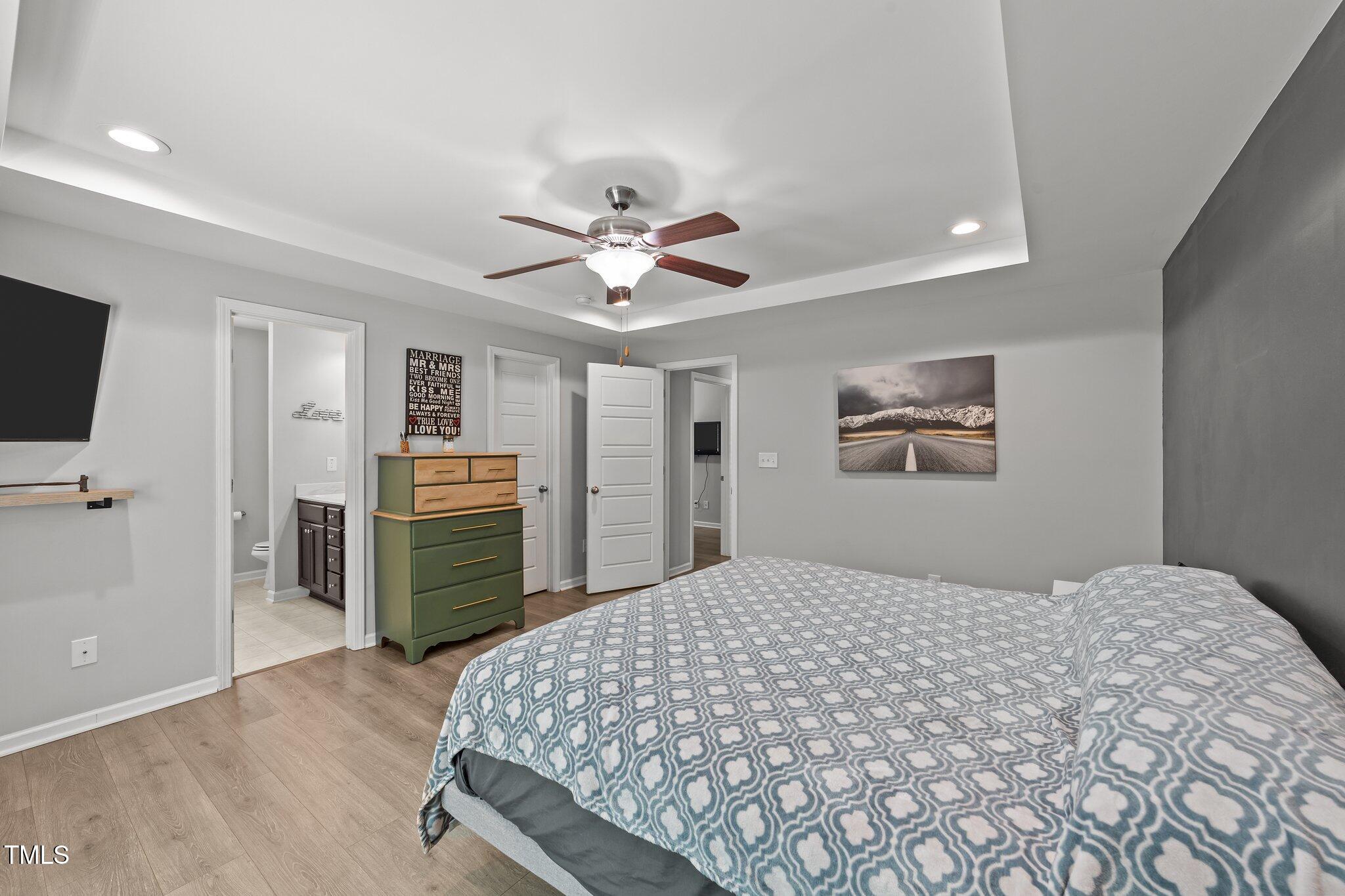 166 Yellow Jacket Ridge Clayton, NC 27520 - Photo 19 of 39 a bedroom with a large bed and a tv