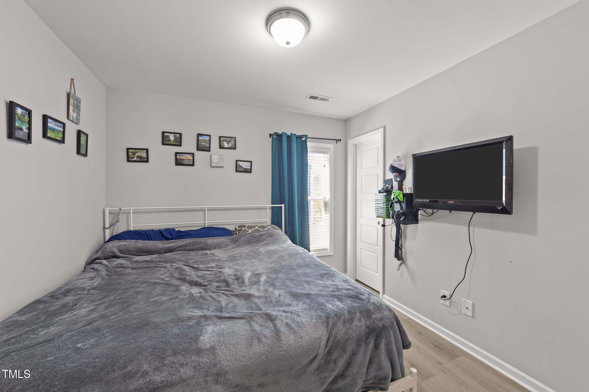 166 Yellow Jacket Ridge Clayton, NC 27520 - Photo 26 of 39 a bedroom with a bed and a flat screen tv