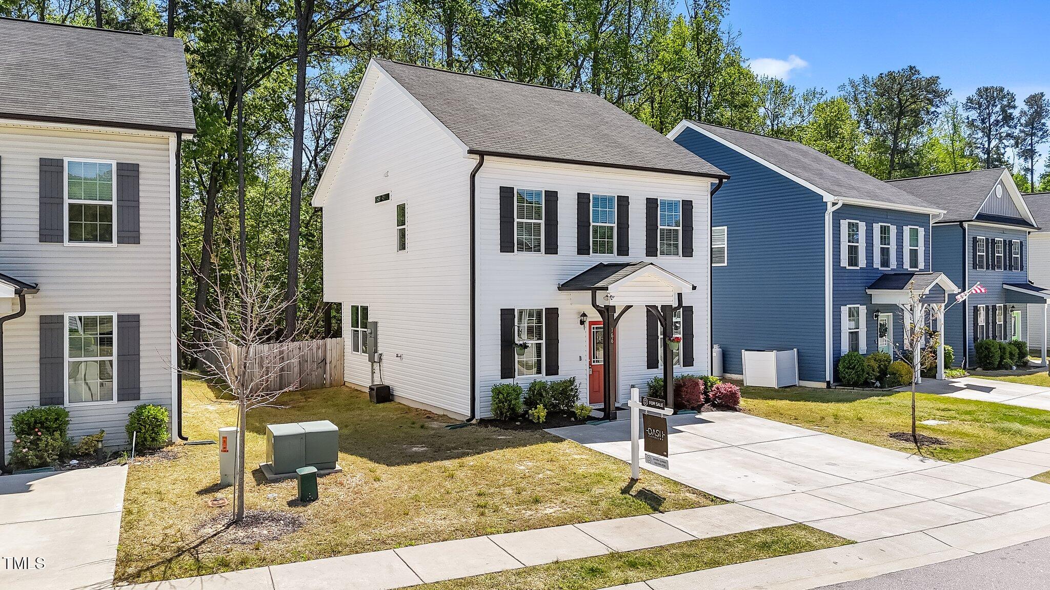 166 Yellow Jacket Ridge Clayton, NC 27520 - Photo 3 of 39 a view of a white house with a fountain plants and large tree