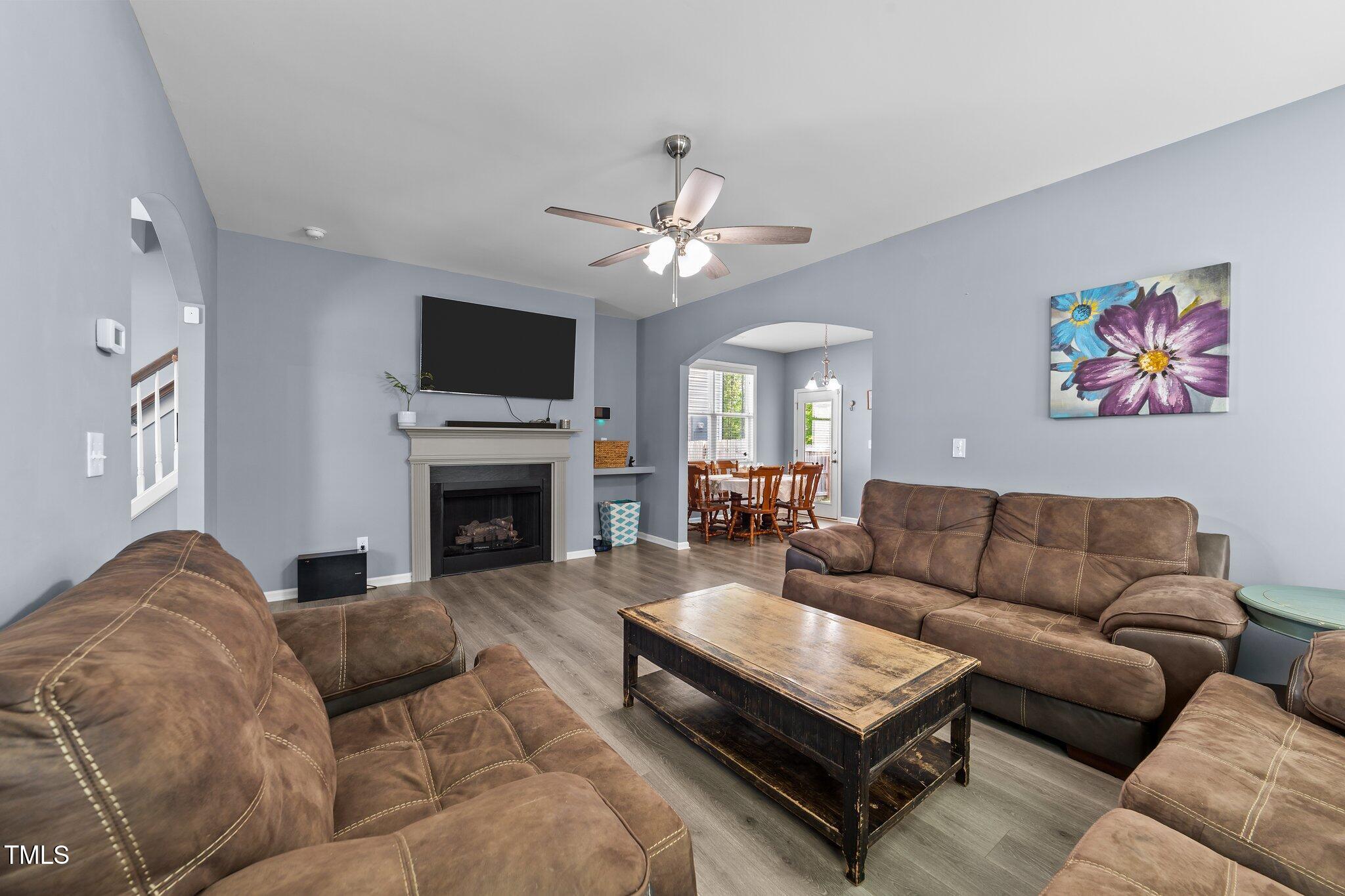 166 Yellow Jacket Ridge Clayton, NC 27520 - Photo 9 of 39 a living room with furniture a flat screen tv and a fireplace